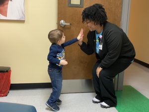 small boy high fives dental assistant